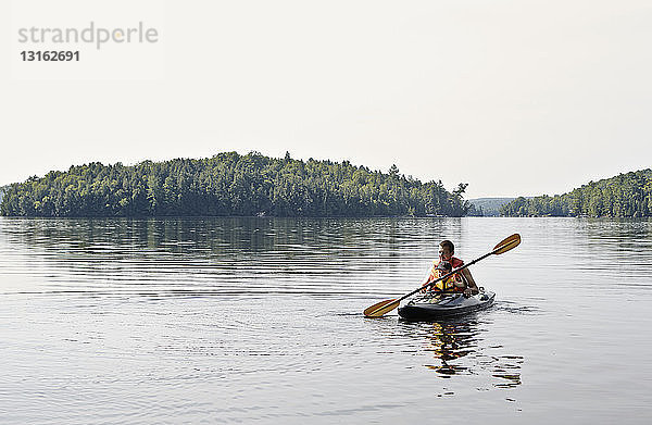 Vater und Sohn beim Kajakfahren auf dem See  Ontario  Kanada