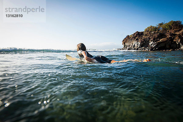 Surfer paddeln im Ozean