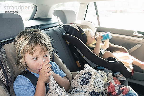 Zwei Jungen in Autositzen