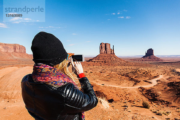 Mittlere erwachsene Frau  die Monument Valley auf einem Smartphone fotografiert  Utah  USA