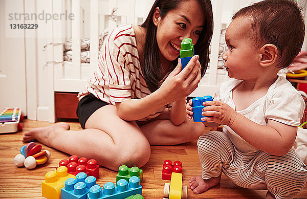 Mutter und kleiner Junge spielen mit Bausteinen