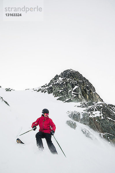 Frontansicht eines jungen Mannes beim Skifahren auf einem schneebedeckten Berg  Whistler Blackcomb Skigebiet  Britisch-Kolumbien  Kanada