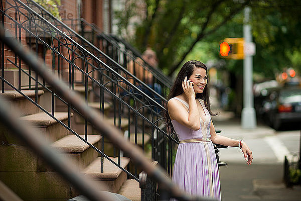 Mittelgroße erwachsene Frauen  die Mobiltelefone benutzen  bei Sandsteinhäusern in Greenwich  New York