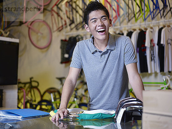 Porträt eines jungen Mannes  der im Fahrradladen lacht