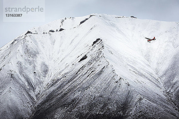 Flugzeug fliegt vor einem schneebedeckten Berg  Wrangell St. Elias  Alaska  USA