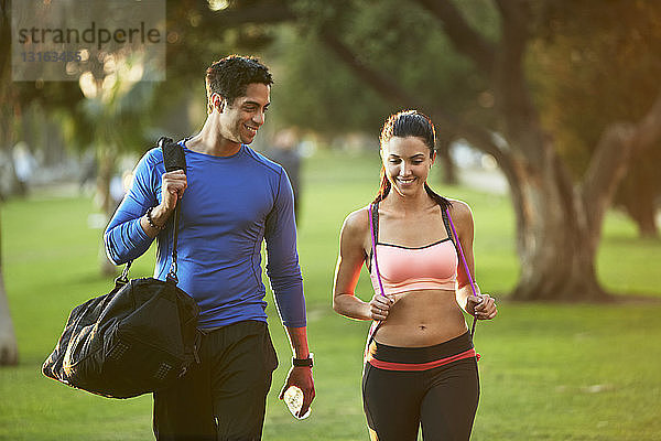 Mann und Frau in Sportkleidung beim Spaziergang durch den Park