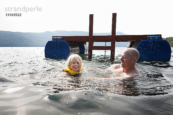 Vater und Kleinkind schwimmen im See  Silver Bay  New York  USA