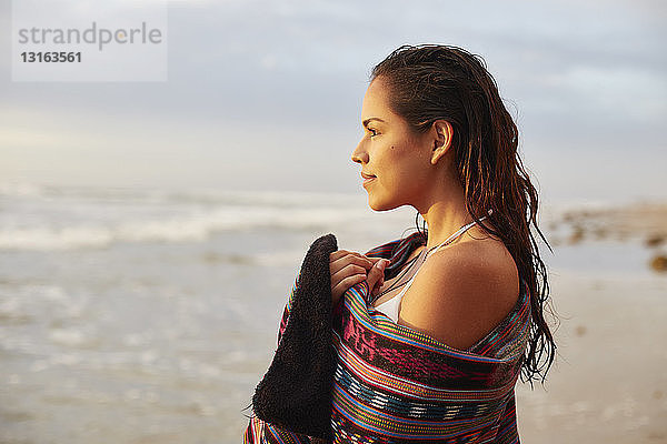 Porträt einer in ein Handtuch gewickelten jungen Frau am Strand  San Diego  Kalifornien  USA