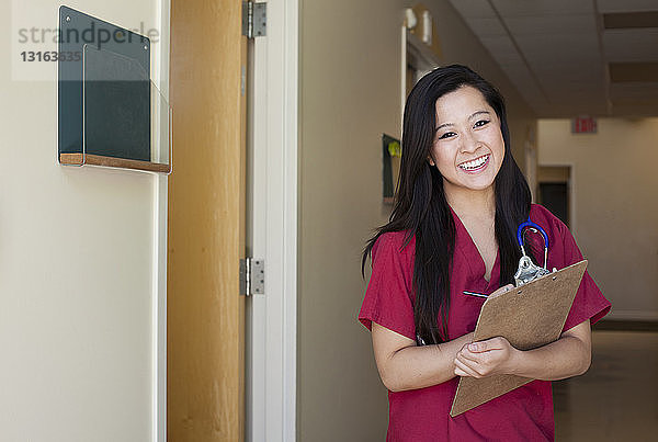 Porträt einer jungen Krankenschwester mit Klemmbrett