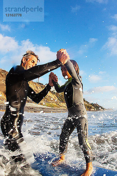 Vater und Tochter springen ins Meer  Encinitas  Kalifornien  USA