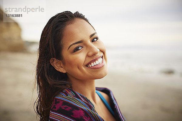Porträt einer lächelnden  in ein Handtuch gewickelten jungen Frau am Strand  San Diego  Kalifornien  USA