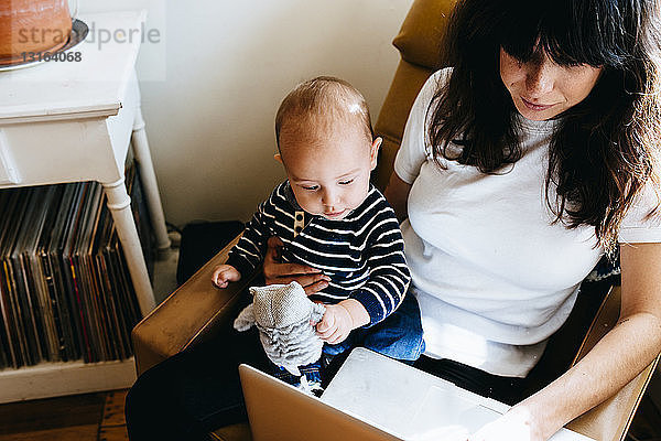 Mutter mit Laptop und Sohn auf dem Schoß