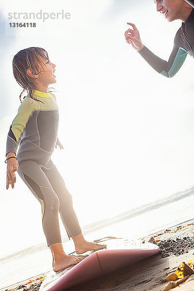 Mutter und Tochter üben sich im Surfen am Strand  Encinitas  Kalifornien  USA