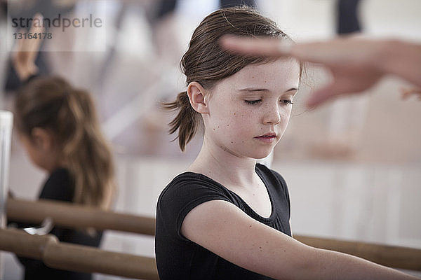 Ballettschülerinnen üben Ballettstellung an der Stange