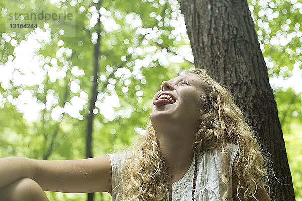 Teenager-Mädchen lacht im Wald
