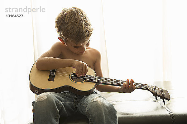 Junge spielt zu Hause Gitarre