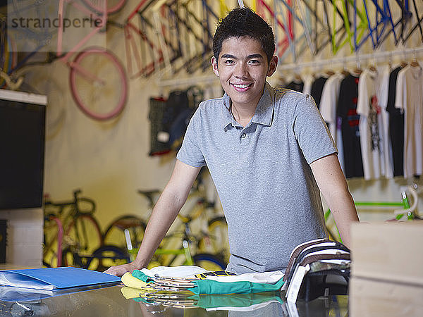 Porträt eines jungen Mannes  der im Fahrradladen in die Kamera schaut