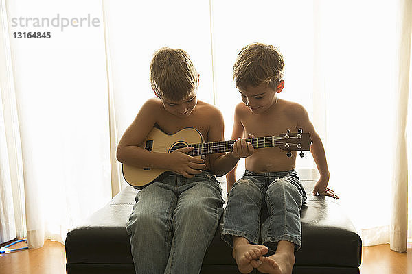 Brüder spielen zu Hause Gitarre