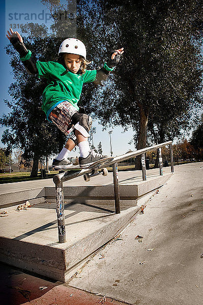 Jungen laufen Schlittschuh im Skatepark