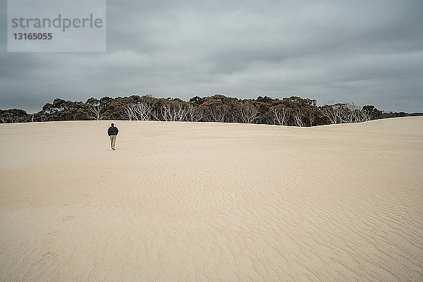 Erwachsener Mann geht auf Sanddünen  Tasmanien