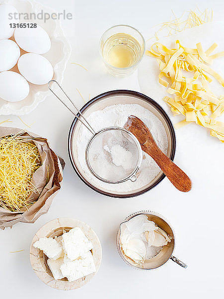 Mehl in Schüssel mit Knoblauch  Eiern und Ziegenkäse