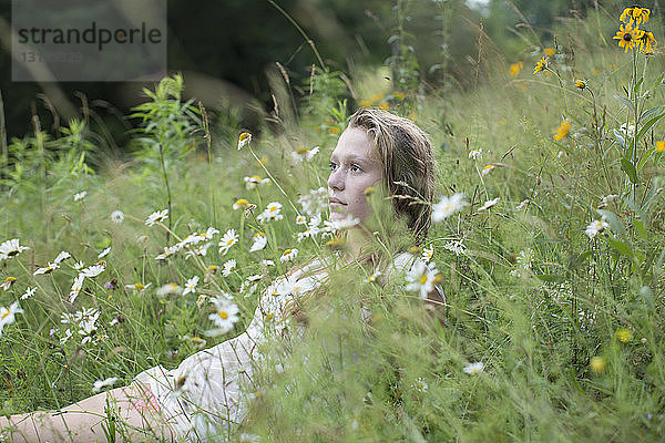 Teenager-Mädchen auf Wildblumen liegend