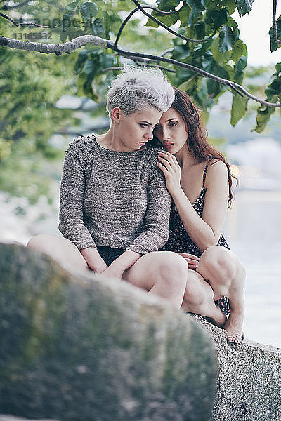 Junge Frauen sitzen auf dem Hafenfelsen