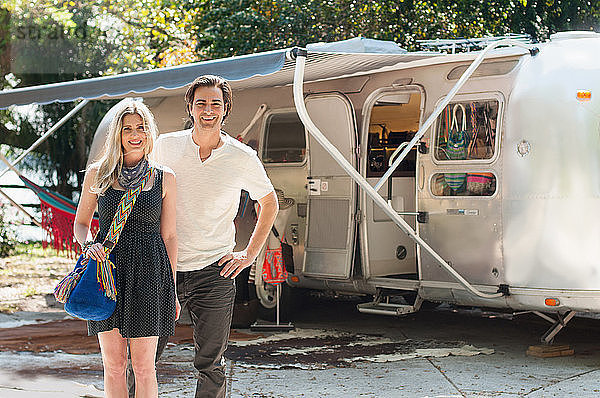 Porträt eines Ehepaares  das vor einem umgebauten Boutique-Airstream-Anhänger steht