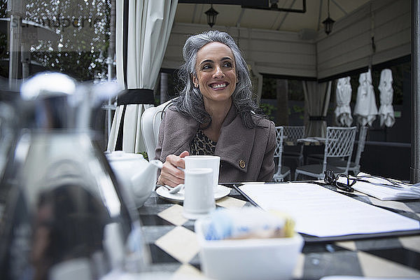 Reife Frau macht Kaffeepause auf Luxus-Veranda