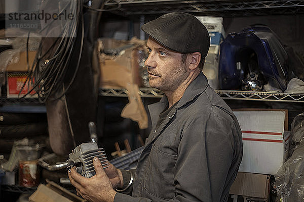 Mechaniker in seiner Garage beim Umbau von gasbetriebenen Motorrädern auf Bio-Diesel