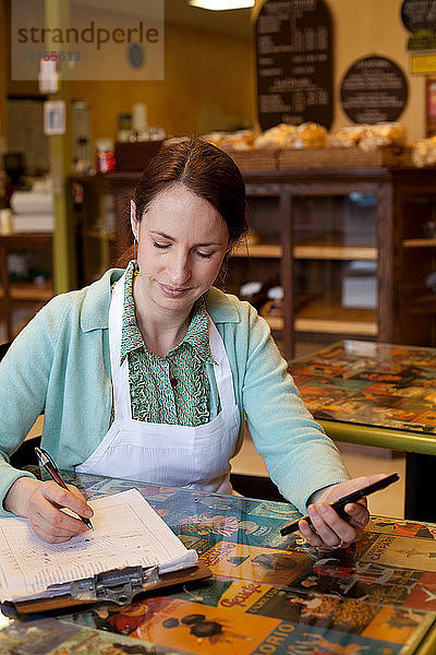 Frau arbeitet auf Konten in Bäckerei