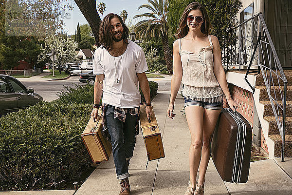 Junges Paar mit Koffern auf der Straße