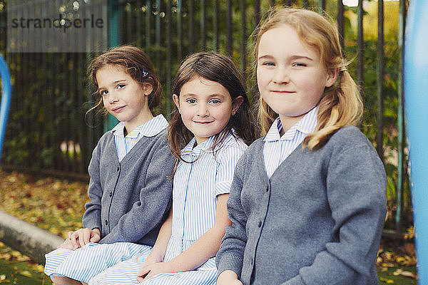 Porträt von drei Grundschülerinnen auf dem Spielplatz