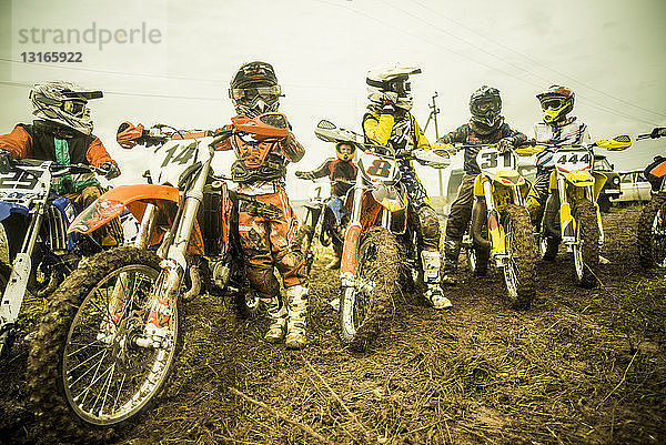 Gruppe von Jungen auf Motorrädern beim Motocross