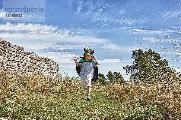 Junge mit grünem Umhang läuft im Gras  Eggegrund  Schweden