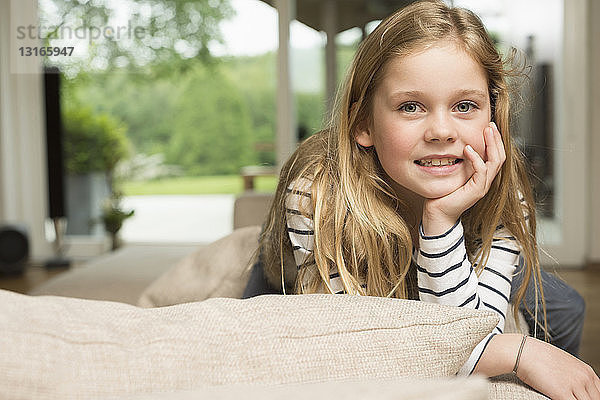 Mädchen halb liegend auf Sofa