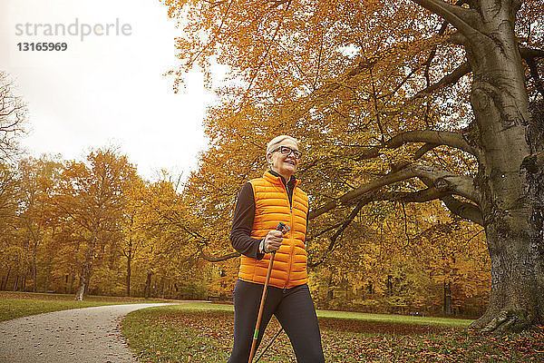 Senioren-Nordic-Walkerin beim Schreiten im Herbstpark