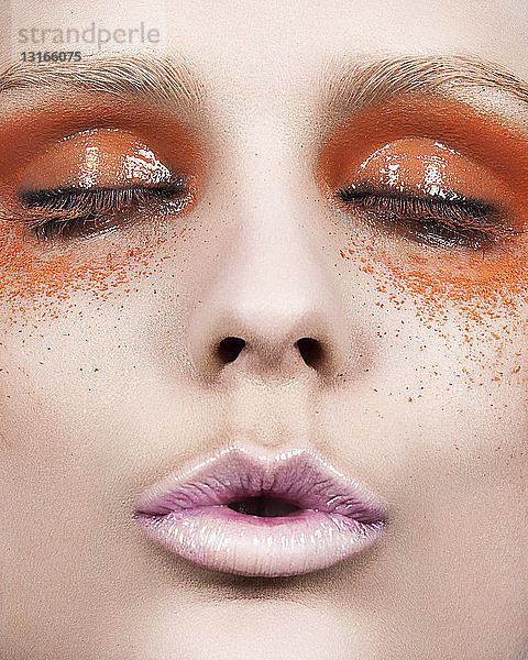 Junge Frau mit orangefarbenem Augen-Make-up  Nahaufnahme