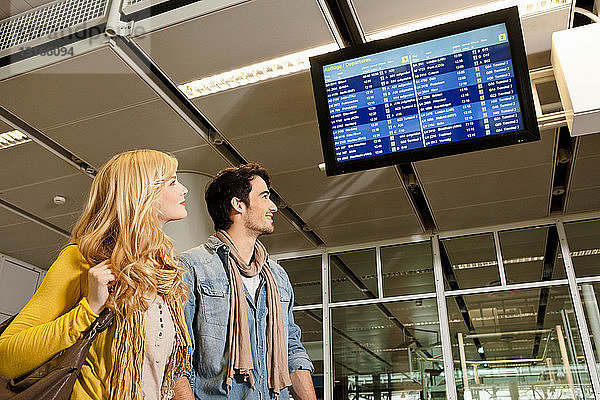 Paar  das Flugzeiten im Flughafen kontrolliert