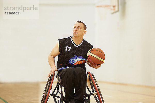 Rollstuhl-Basketballspieler hält Ball
