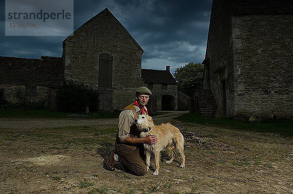 Porträt eines reifen  traditionellen Bauern und seines taumelnden Hundes