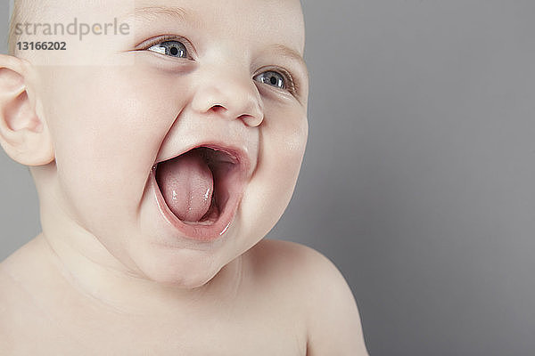 Ausgeschnittenes Studioporträt eines lächelnden kleinen Jungen mit offenem Mund