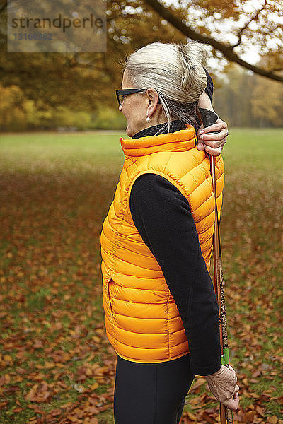 Senioren-Nordic-Walkerin übt mit Wanderstöcken im Park