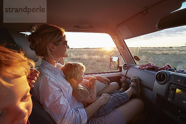 Mutter und Söhne reisen im Fahrzeug  Nxai-Pan-Nationalpark  Kalahari-Wüste  Afrika