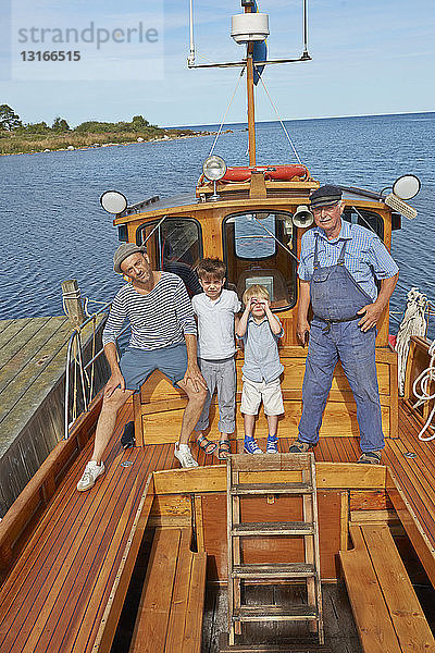 Vater und zwei Söhne mit Fischer auf Boot  Eggegrund  Schweden