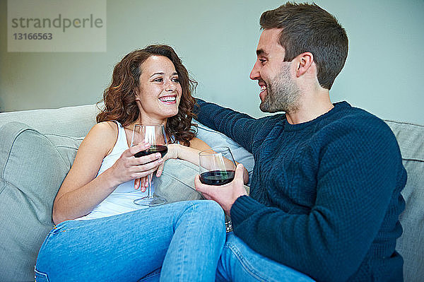 Ehepaar genießt Wein auf dem Sofa