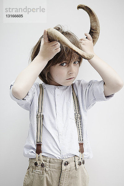 Junge posiert mit Tierhorn