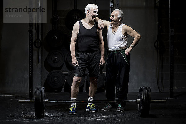 Ältere Männer unterhalten sich in dunkler Turnhalle