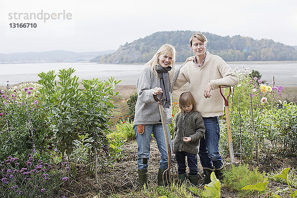 Porträt von Ehepaar und Sohn beim Graben eines biologischen Gartens  Orust  Schweden
