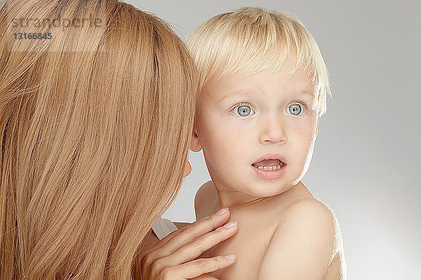 Mutter hält überraschten Jungen